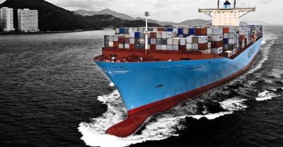 Duży niebieski kontenerowiec płynie po morzu.