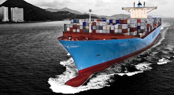 Duży niebieski kontenerowiec płynie po morzu.